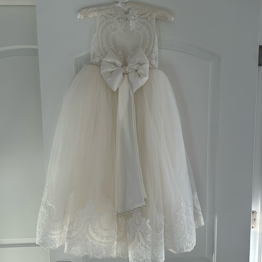 Stunning communion dress with lace detailing and satin bow.